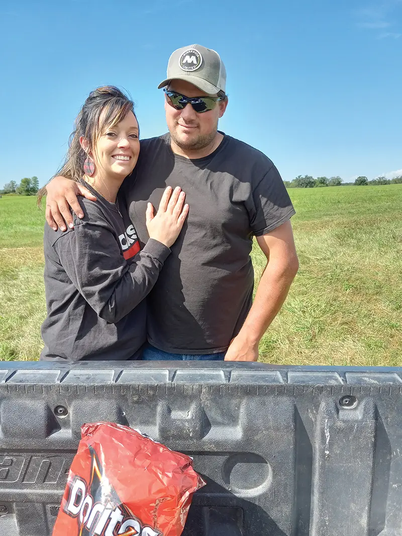 two people standing together in a field